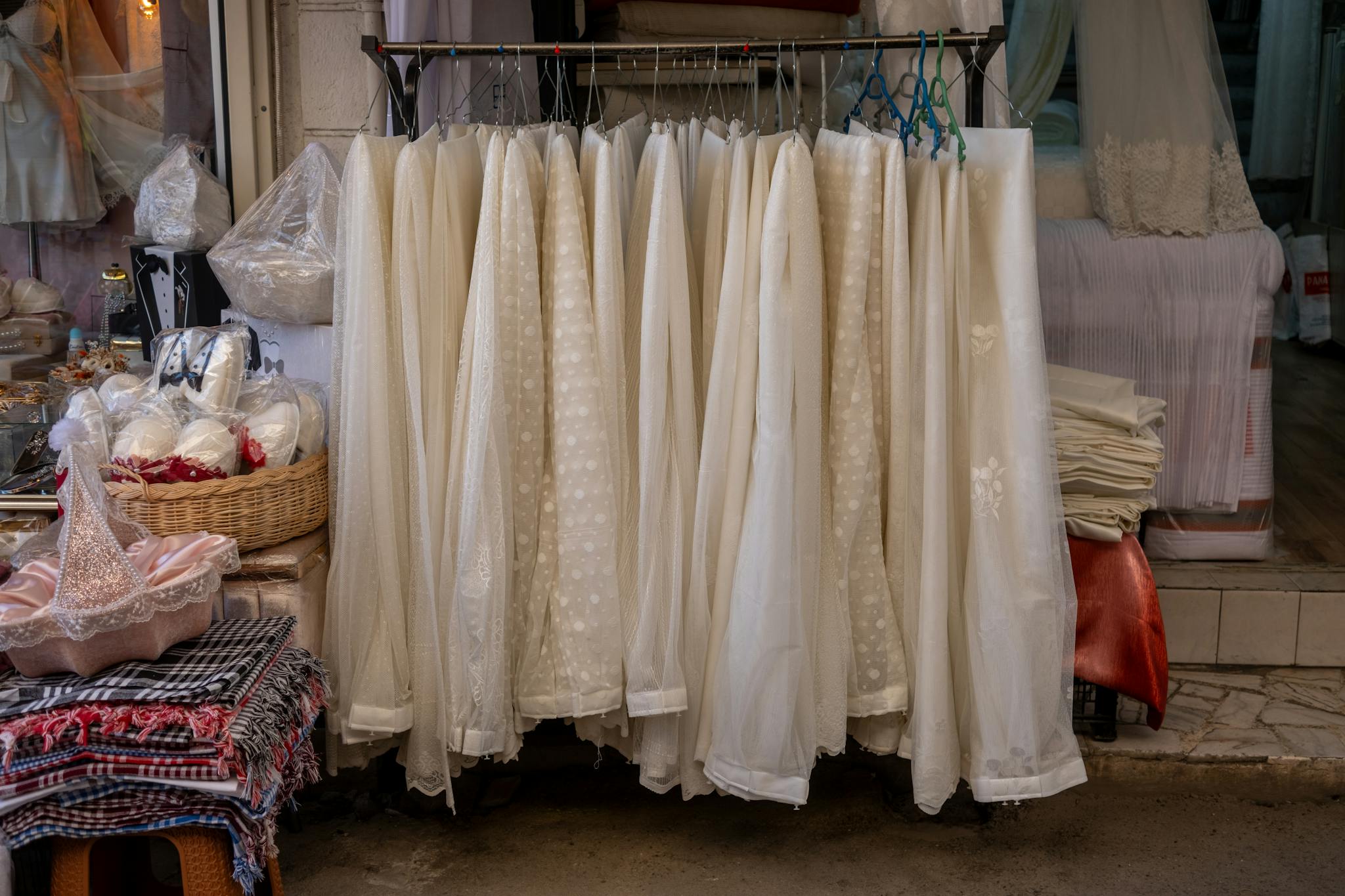 A collection of elegant white fabrics and lace crafts on display in a boutique shop in İzmir, Türkiye.