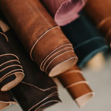 Close-up of assorted multicolored leather rolls in a craftsman workshop setting.