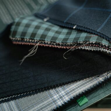 High-quality fabric swatches in various patterns for custom tailoring.